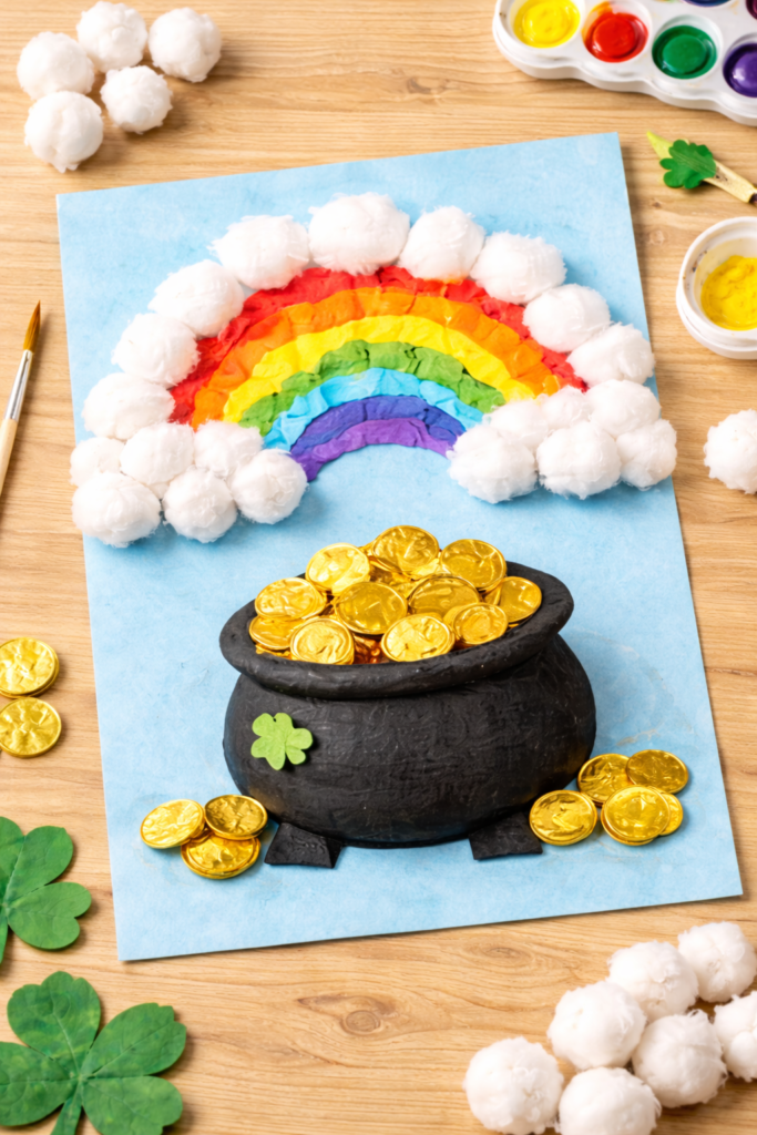 image of cotton ball rainbow craft with painted fluffy texture, black paper pot of gold at bottom, gold coins detail