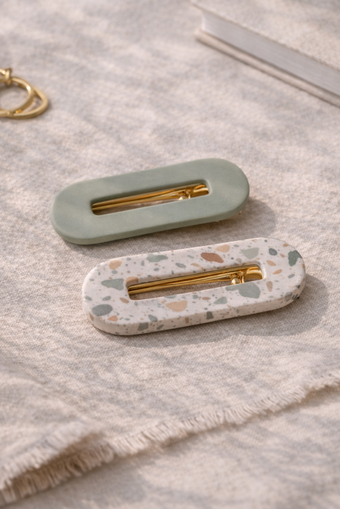 modern polymer clay hair clips in muted sage and terrazzo pattern, arranged on neutral linen