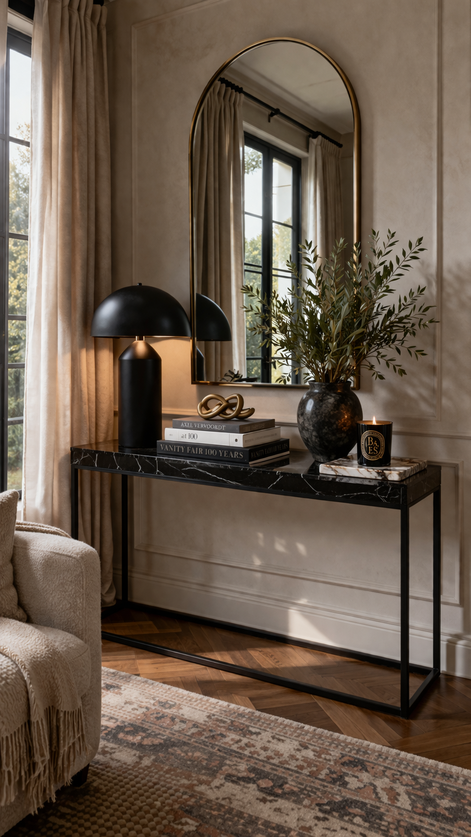 Living room wall with dramatic black metal and marble console table styled with mirror, lamp, and curated objects