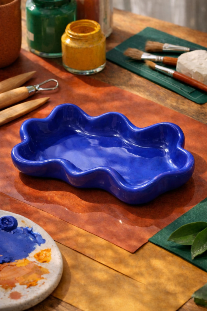 clay tray ideas - handmade wavy edge clay trinket tray placed on a colorful craft table
